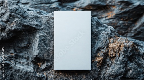 This image features a rectangular metal sheet with a sleek finish, placed on a rugged, natural rocky surface, showcasing a beautiful juxtaposition of materials.