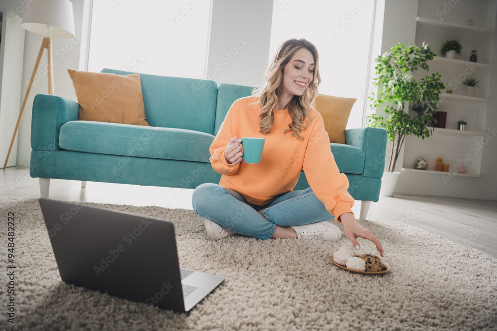 Φωτογραφία Full size photo of young woman sit floor watch movie netbook eat snacks dressed