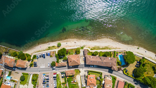 An aerial view of Domaso, a beautiful village nestled on the shores of Lake Como, Italy, captured by a drone. This charming destination is known for its picturesque lakeside scenery, quaint streets photo