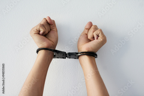 Hands, restriction and person with handcuffs by white wall for mental health, anxiety and struggle. Depression, captivity and wrist with shackle for internal prison, control and psychological barrier