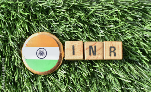 A closeup picture of letters INR with Indian flag badge photo