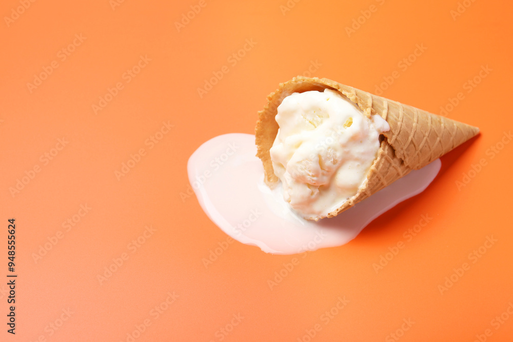 Melted ice cream in wafer cone on orange background. Space for text Melted ice cream in wafer cone on orange background. Space for text