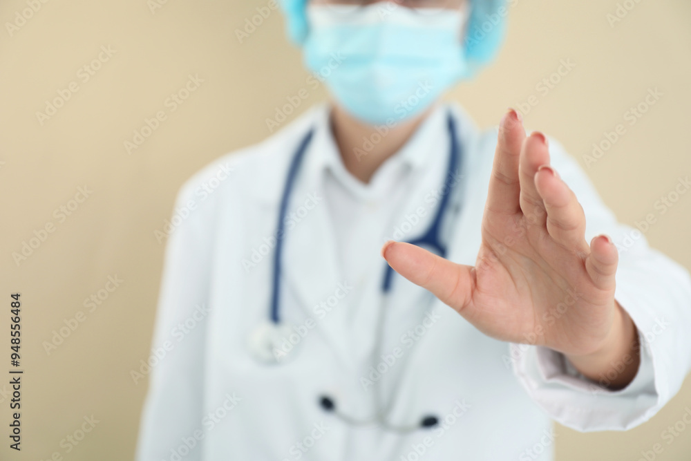 Doctor holding something on beige background, closeup Doctor holding something on beige background, closeup