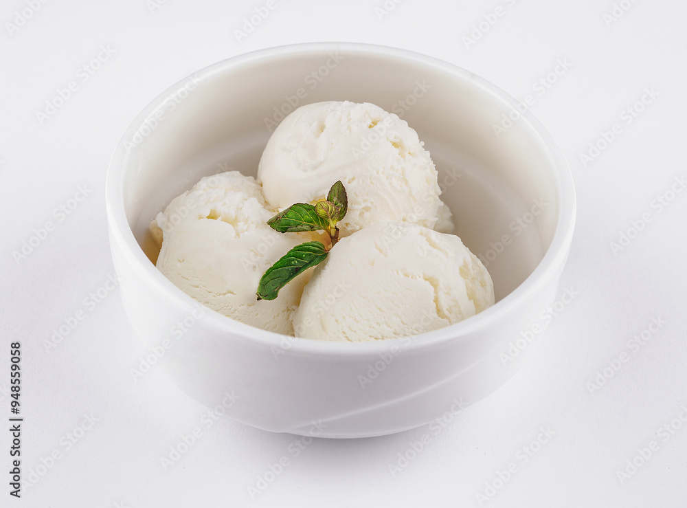 Three scoops of vanilla ice cream with mint leaf on white background