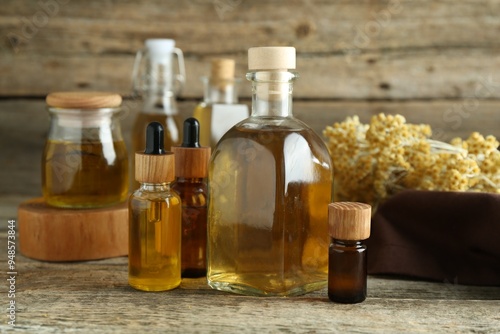 Different tinctures and helichrysum flowers on wooden table