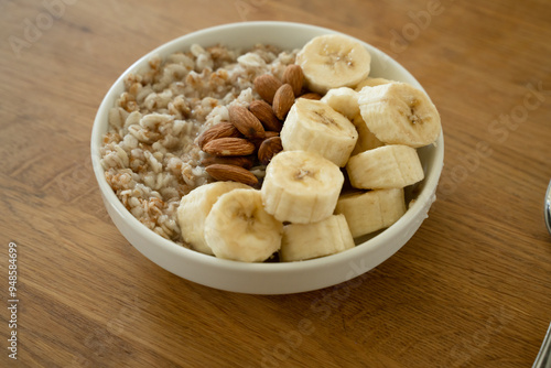 Oatmeal with banana, honey and almonda for breakfast on a table photo