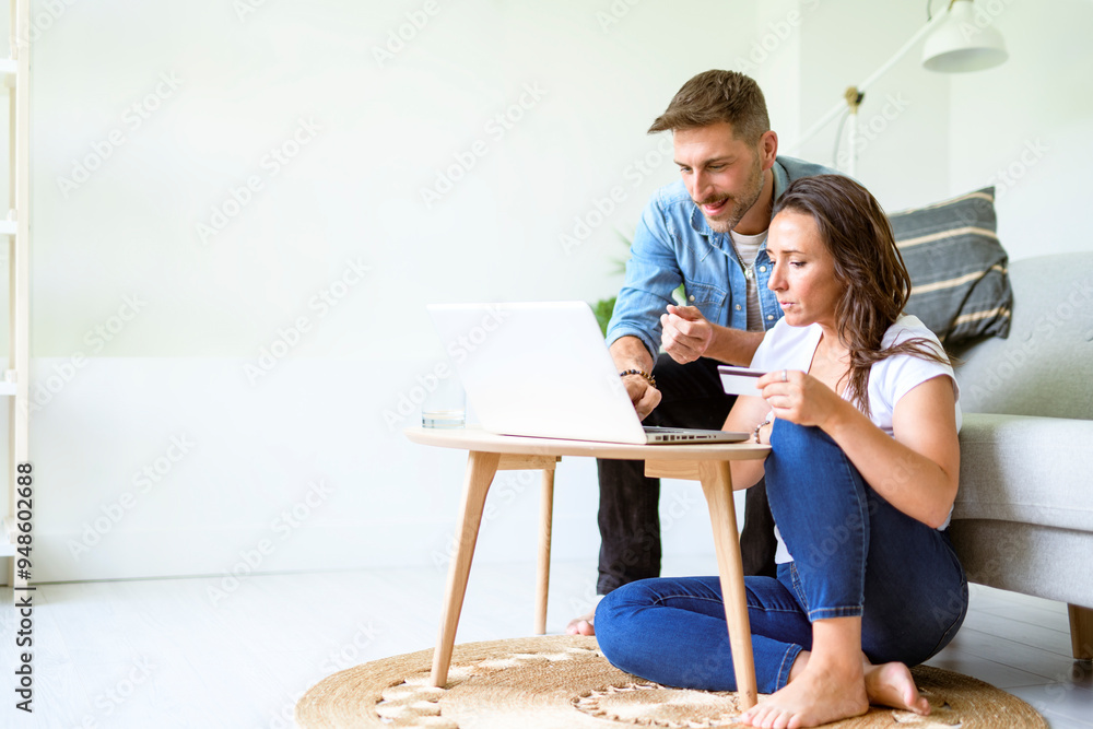 bearded husband cuddling affectionate wife on computer at home. Using laptop in living room. bearded husband cuddling affectionate wife on computer at home. Using laptop in living room.