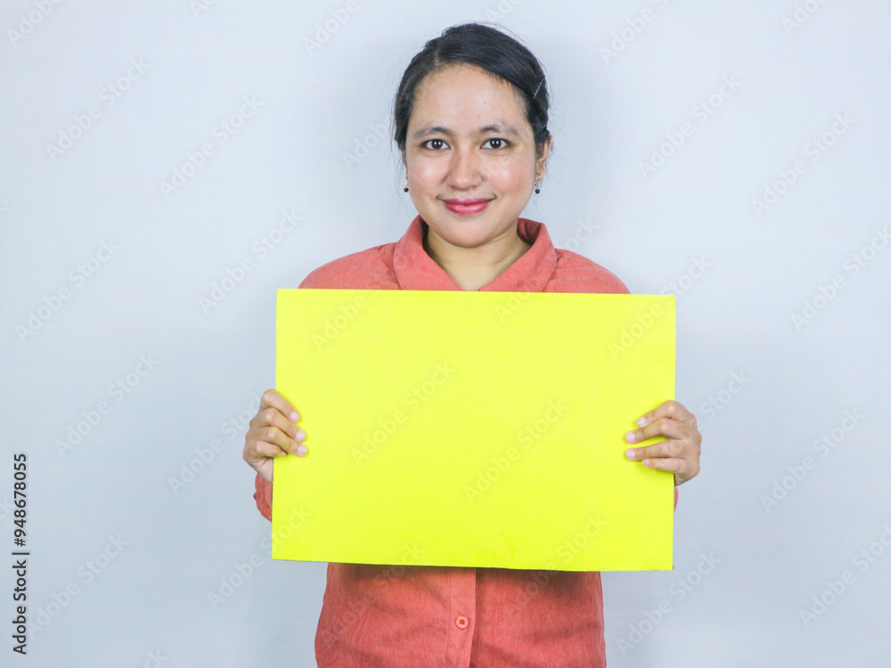 beautiful asian woman hold a blank yellow sheet in his hands. Place for text. beautiful asian woman hold a blank yellow sheet in his hands. Place for text.