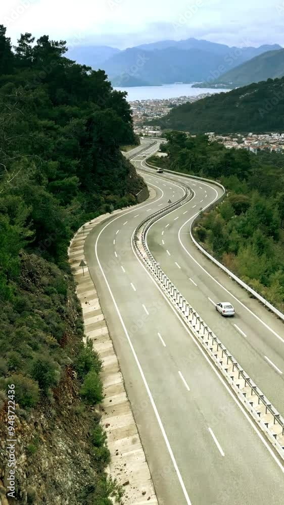 Aerial view of a mountain road and distant city of Marmaris in Turkey, vertical video