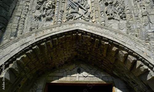 Close-up of intricate stone carvings on a medieval castle wall, showcasing detailed Gothic artwork. photo