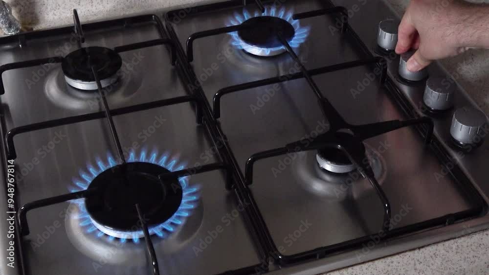 Top view of the gas stove being lit and the gas being turned off in the kitchen. Top view of the gas stove being lit and the gas being turned off in the kitchen.