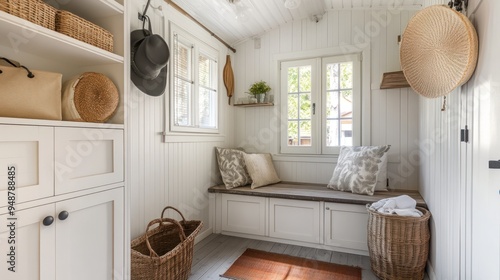 White room interior with a bench, cabinets, and a basket filled with white towels.
