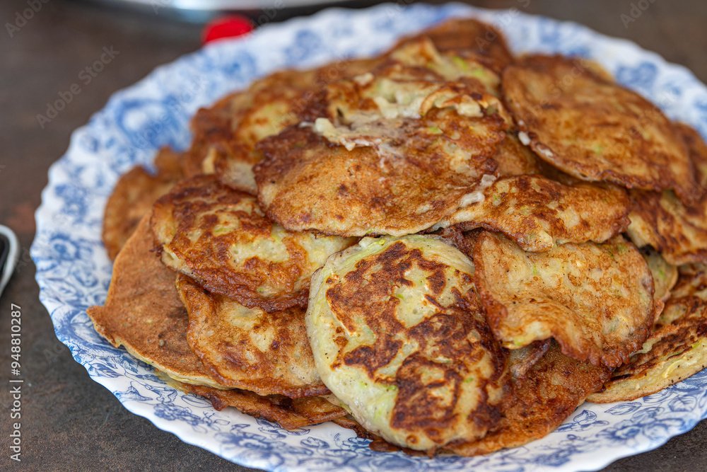 Prepared zucchini pancakes on a plate. Coocking at home concept. Prepared zucchini pancakes on a plate. Coocking at home concept.