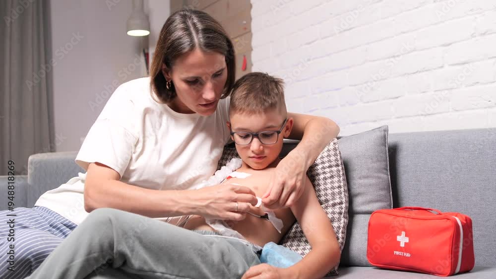 Mother applying electrodes of a holter monitor to her preteen son Mother applying electrodes of a holter monitor to her preteen son