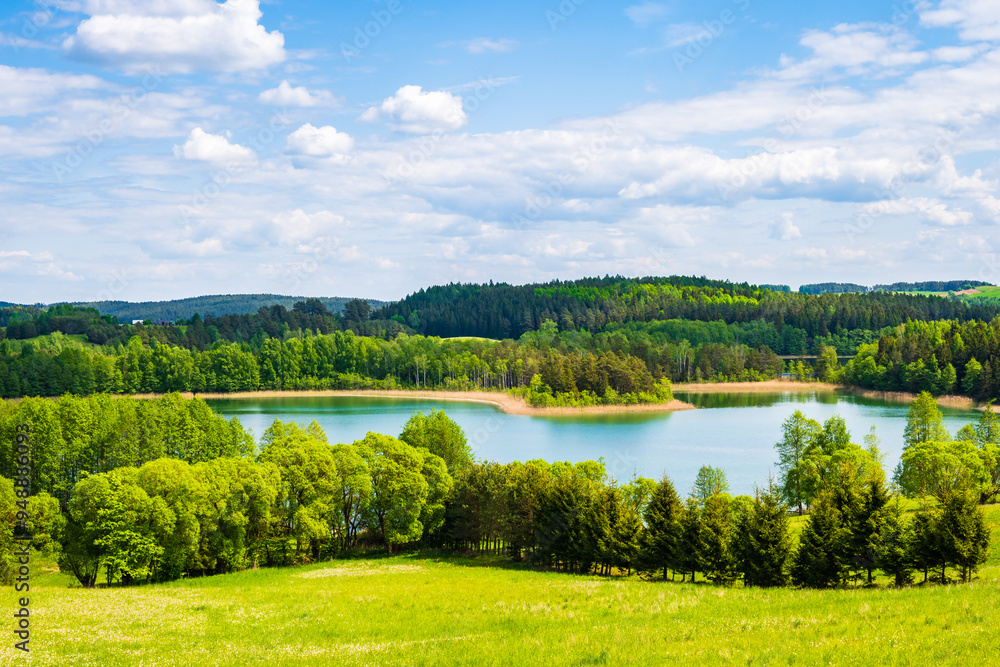 Obraz premium View of Jaczno lake from hill with green meadow and trees, Suwalski Landscape Park, Podlasie, Poland