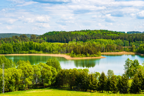 View of Jaczno lake from hill with green meadow and trees, Suwalski Landscape Park, Podlasie, Poland photo