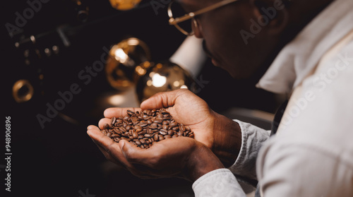 Coffee roaster machine and afro american man worker barista testing aroma of fresh beans. Concept banner roasting process