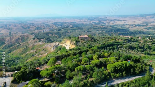 An aerial view of Le Balze di Volterra and the San Giusto Volterra in Tuscany, Italy, captured by a drone. Le Balze di Volterra is a dramatic and unique landscape of steep cliffs photo