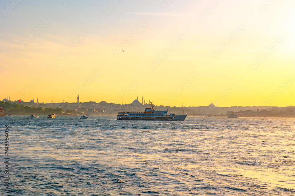 Obraz premium Istanbul view at sunset with cityscape of Istanbul and a ferry.