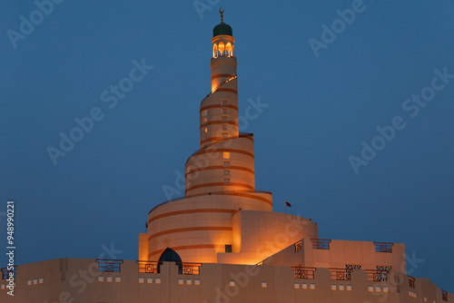 Al Fanar Building at night with blue sky which is one of the most famous landmarks in Doha, characterized by its spiral shape, and is located near Souq Waqif, Doha, Qatar shot take on ‎July ‎3, ‎2024.
