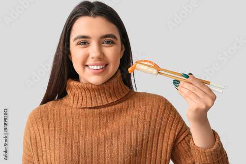 Young woman with sushi on l...