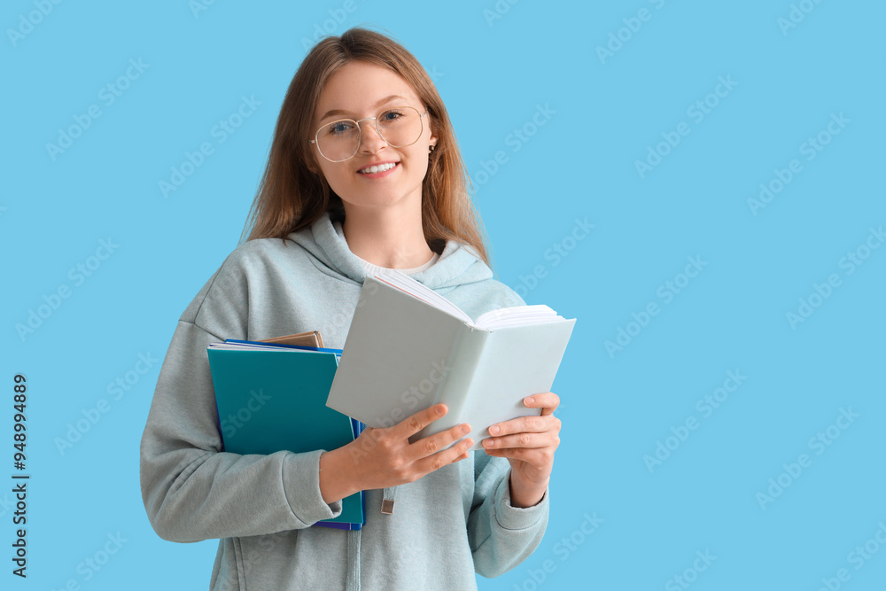 Happy female student with different books on blue background Happy female student with different books on blue background