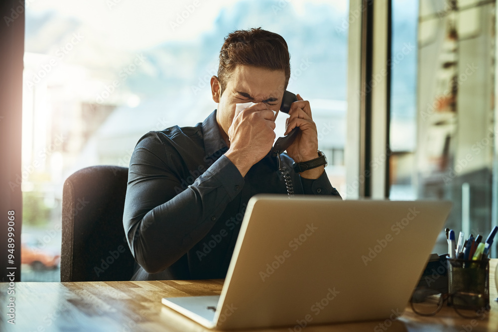Blowing nose, laptop and phone call of business man in corporate office with cold or flu symptoms. Computer, landline and tissue with professional employee sneezing in workplace for communication Blowing nose, laptop and phone call of business man in corporate office with cold or flu symptoms. Computer, landline and tissue with professional employee sneezing in workplace for communication