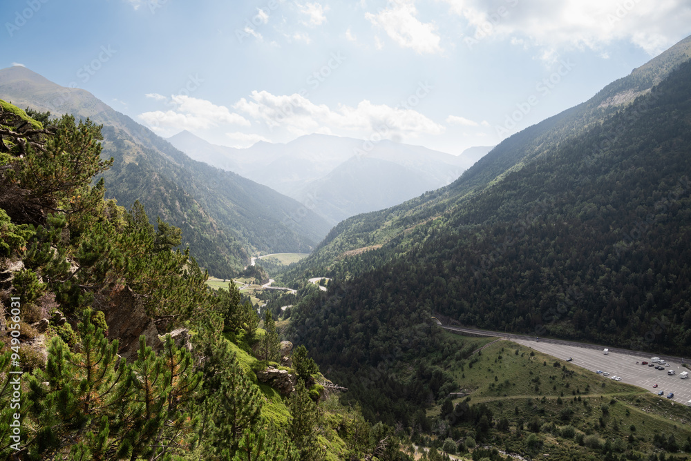 Obraz premium Panoramic view of a mountainous landscape with a winding road and dense forests