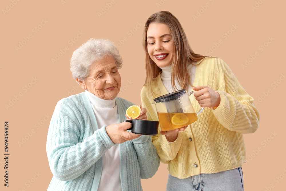 Young woman and her grandmother pouring lemon tea into cup on beige background Young woman and her grandmother pouring lemon tea into cup on beige background
