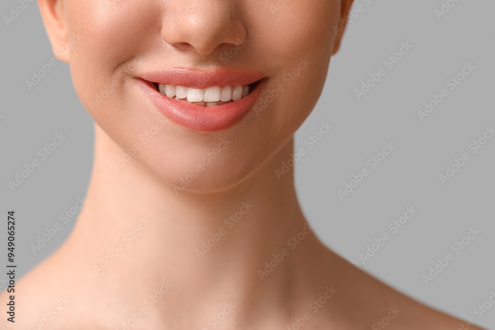 Smiling young woman with beautiful lips on grey background, closeup Smiling young woman with beautiful lips on grey background, closeup