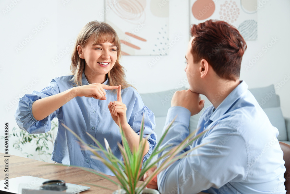 Young deaf mute woman with her husband using sign language at home Young deaf mute woman with her husband using sign language at home