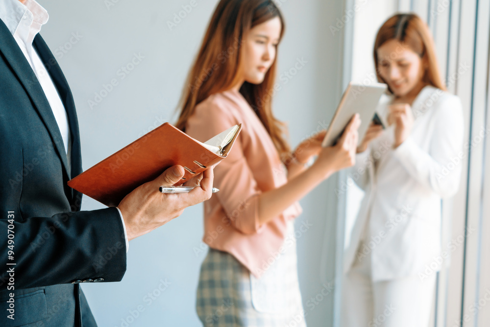 Happy young handsome businessman reading book and working in office with colleagues and friend at workplace. Corporate business people group. uds