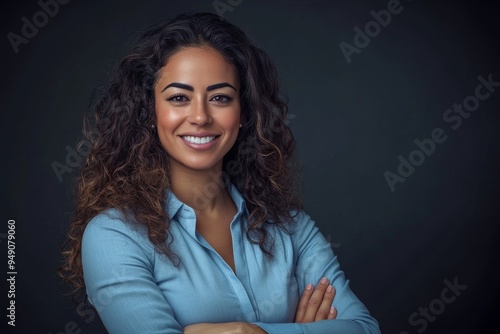 Against a neutral background, young psychologist poses with brown curls, bright eyes, and a friendly smile.