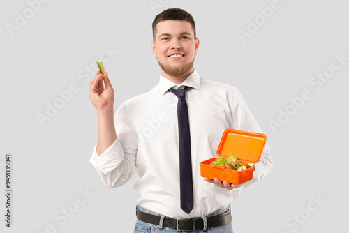 Young man holding lunch box...