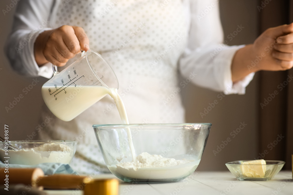 Woman preparing traditional cinnamon rolls in kitchen Woman preparing traditional cinnamon rolls in kitchen