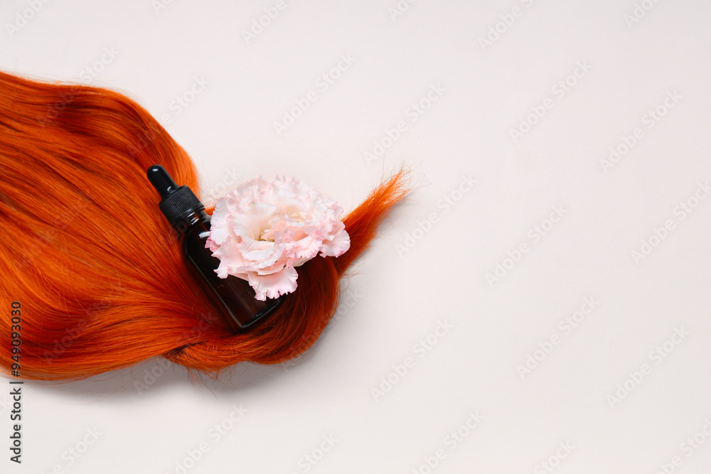 Φωτογραφία Red hair strand with flower and bottle of cosmetic product on light background
