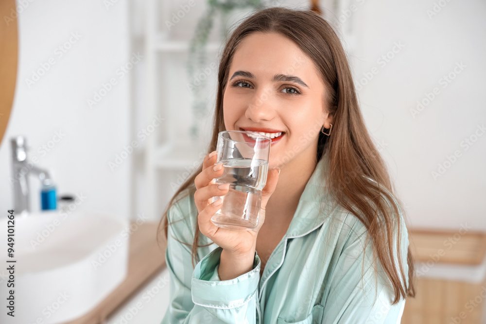 Young woman drinking water in bathroom, closeup Young woman drinking water in bathroom, closeup