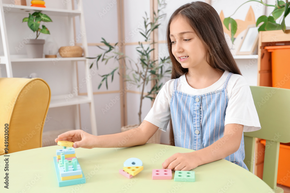 Cute little girl with building blocks on table at home Cute little girl with building blocks on table at home