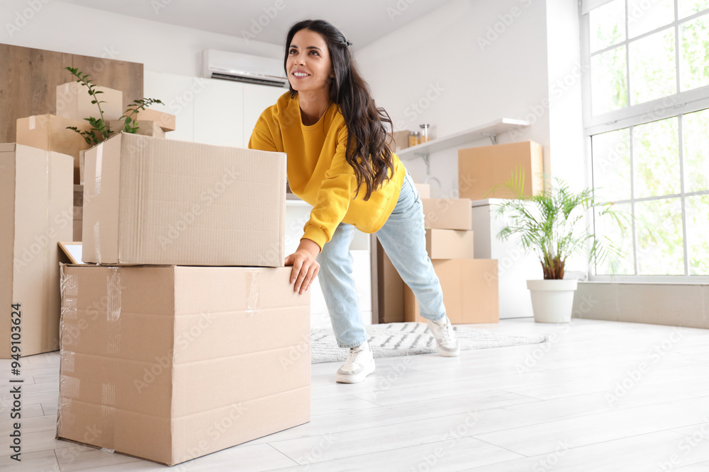 Beautiful woman carrying boxes in kitchen on moving day Beautiful woman carrying boxes in kitchen on moving day