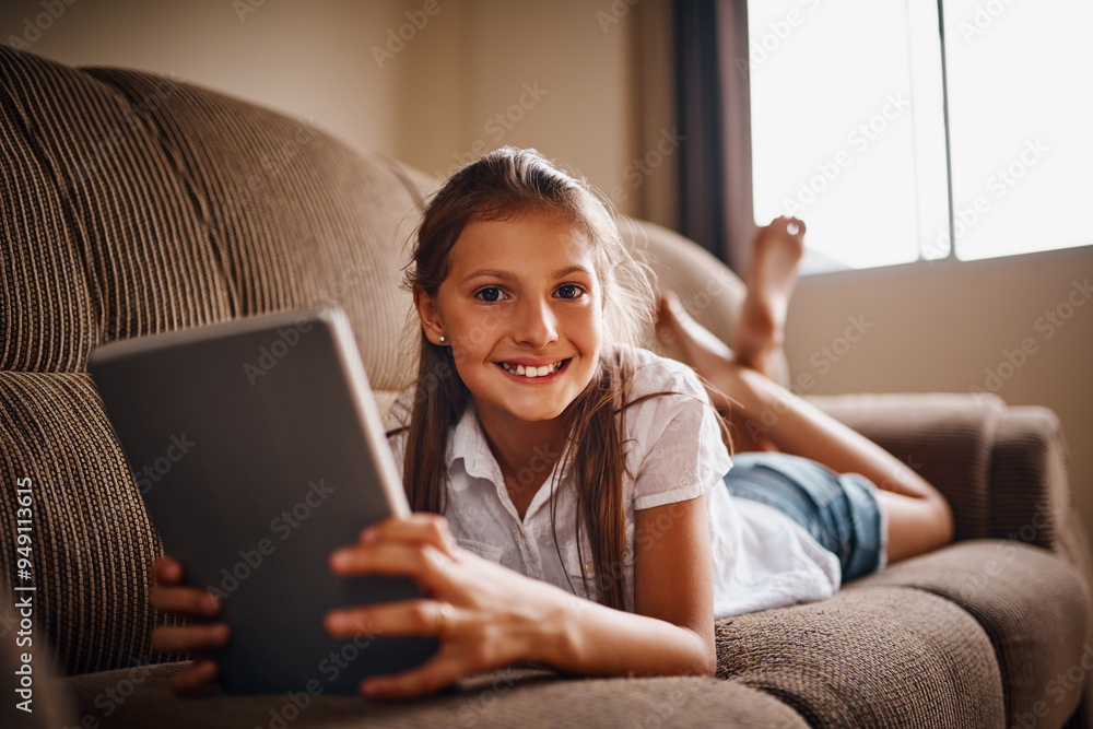 Elearning, portrait and tablet with girl student on sofa in living room of home for development, education or study. Reading, smile and technology with happy child in apartment for remote schooling Elearning, portrait and tablet with girl student on sofa in living room of home for development, education or study. Reading, smile and technology with happy child in apartment for remote schooling