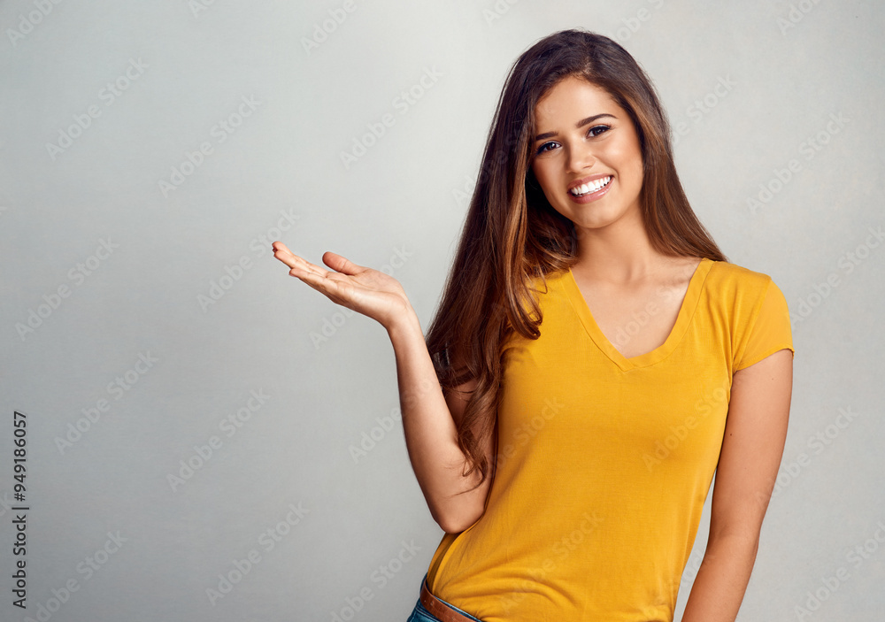 Portrait, woman and gesture with presentation in studio for announcement, information and advertising. Female person, smile and hand with mockup space for news, marketing and promo on gray background Portrait, woman and gesture with presentation in studio for announcement, information and advertising. Female person, smile and hand with mockup space for news, marketing and promo on gray background