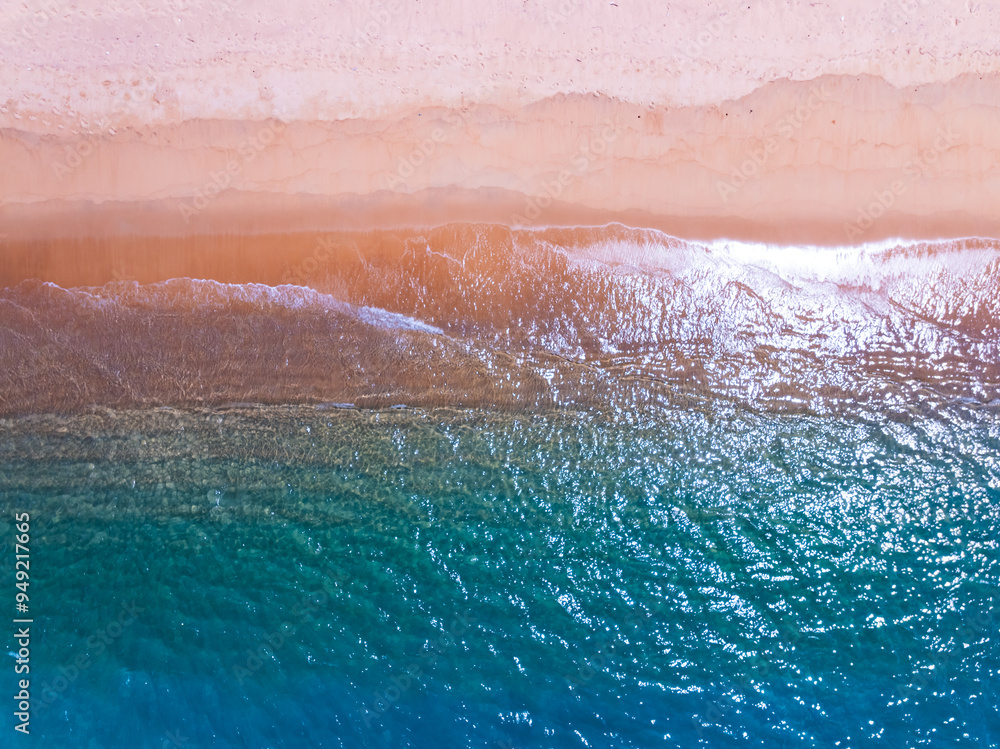 Fototapeta premium Beautiful sea summer landscape, Waves sea water surface High quality video Bird's eye view, Drone top view waves crashing on sand beach,Nature ocean sea beach background