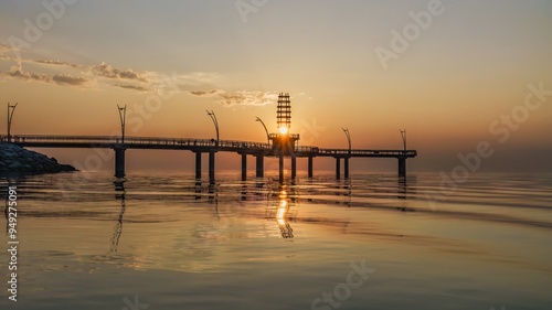 Fototapeta Naklejka Na Ścianę i Meble -  The sun beams through the tower of Brant Street Pier, as it rises over the lake during the morning at Burlington, Ontario, Canada