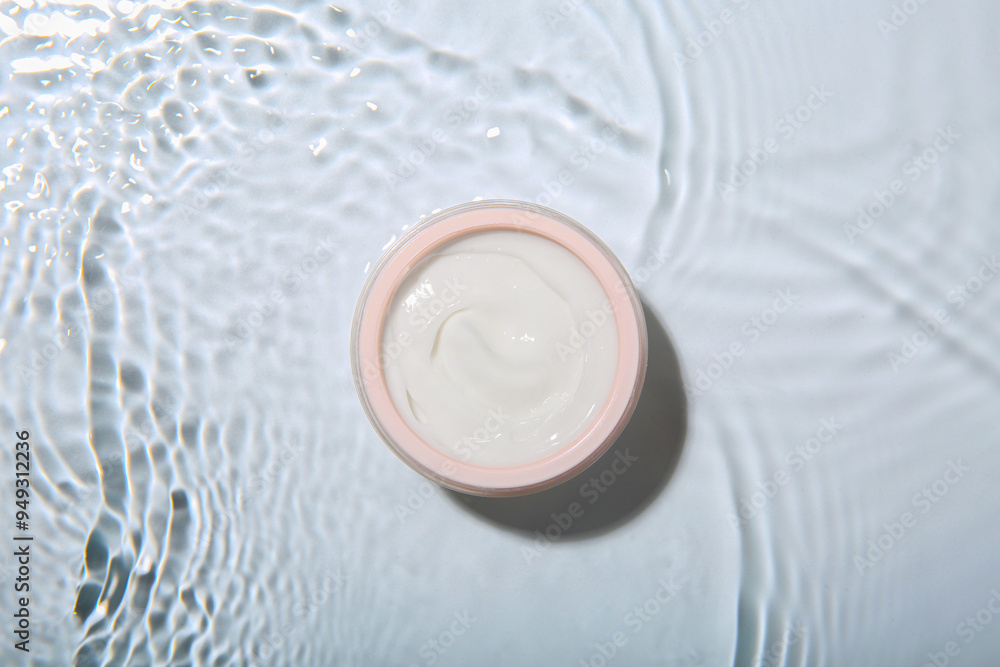 Cosmetic product. Jar with cream in water on light background, top view Cosmetic product. Jar with cream in water on light background, top view