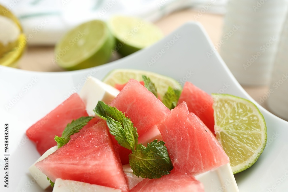 Tasty salad with watermelon, feta cheese, lime and mint in bowl, closeup Tasty salad with watermelon, feta cheese, lime and mint in bowl, closeup