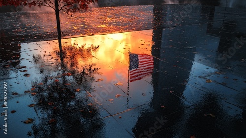Ground Zero Memorial with an American flag reflecting in the water as the sun sets