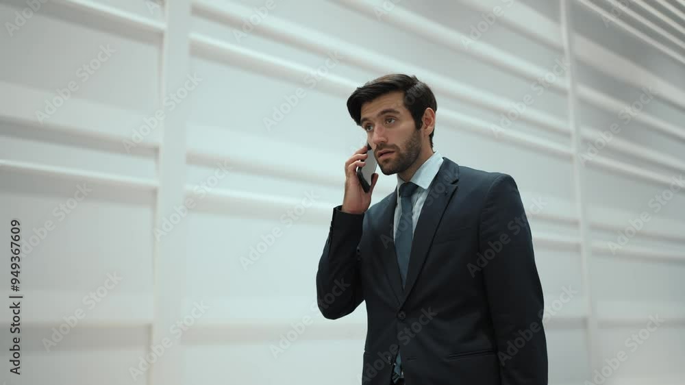 Skilled manager using phone call to contact colleague about project. Handsome male leader calling his business team to report and discuss about sales while standing at white background. Exultant. Skilled manager using phone call to contact colleague about project. Handsome male leader calling his business team to report and discuss about sales while standing at white background. Exultant.