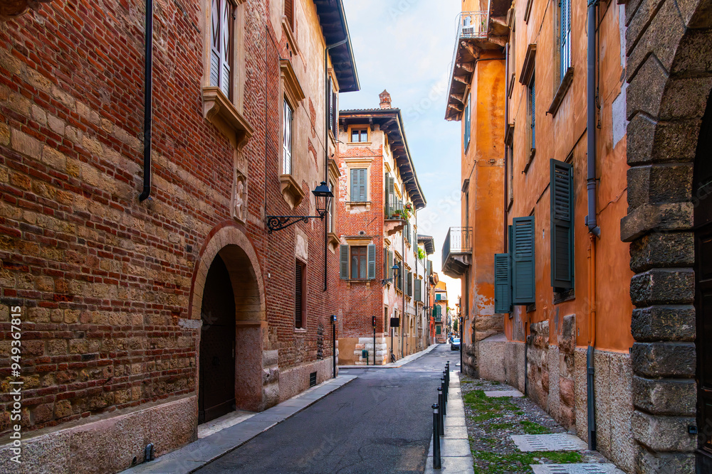 Obraz premium A deserted narrow street at dusk in the historic medieval Citta Antica old town of Verona, Italy.