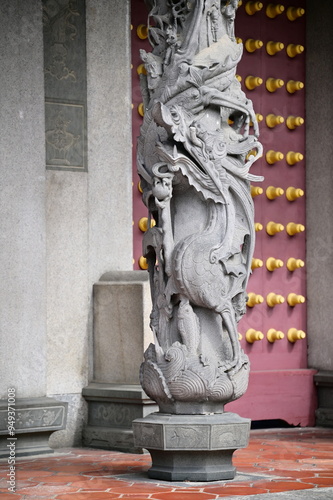 Close-up of the Panlong stone pillars at Taipei Confucius Temple, symbolizing power and Confucian wisdom with intricately carved dragons. photo