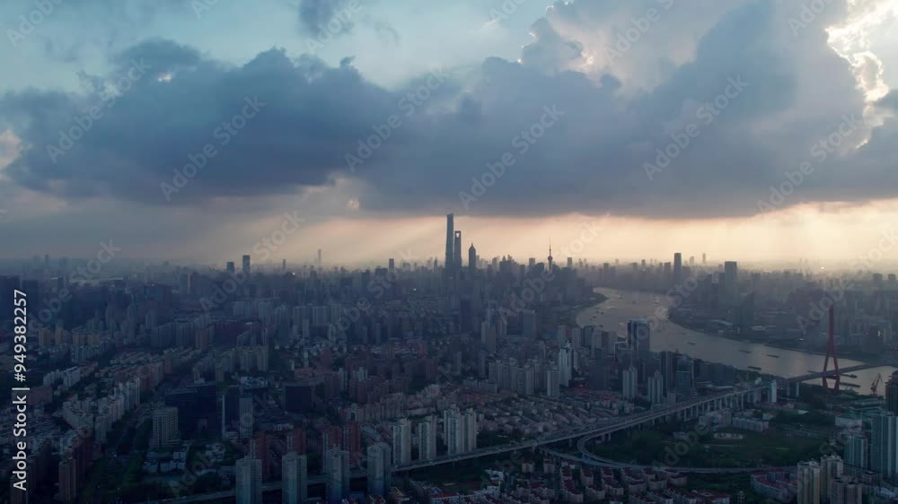 Drone view of Shanghai city in sunny cloudy day at sunset, high angle view of ships sailing on Huangpu river and modern buildings with golden lights moving on sky, 4k real time panning footage. Drone view of Shanghai city in sunny cloudy day at sunset, high angle view of ships sailing on Huangpu river and modern buildings with golden lights moving on sky, 4k real time panning footage.